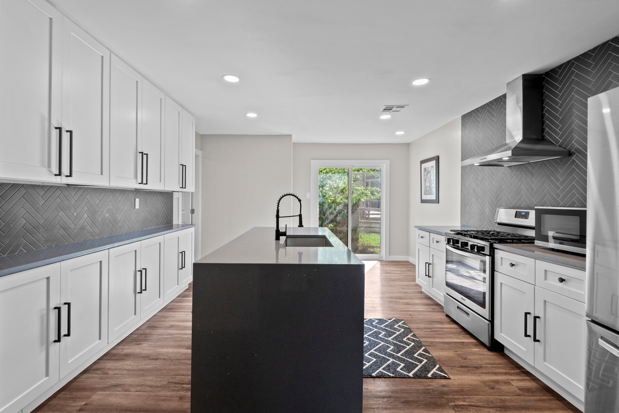 11811 Rotherham Drive Austin, TX 78754 - Photo 8 of 37 A sleek, modern kitchen boasts an inviting island with sink, perfect for culinary endeavors and casual dining.