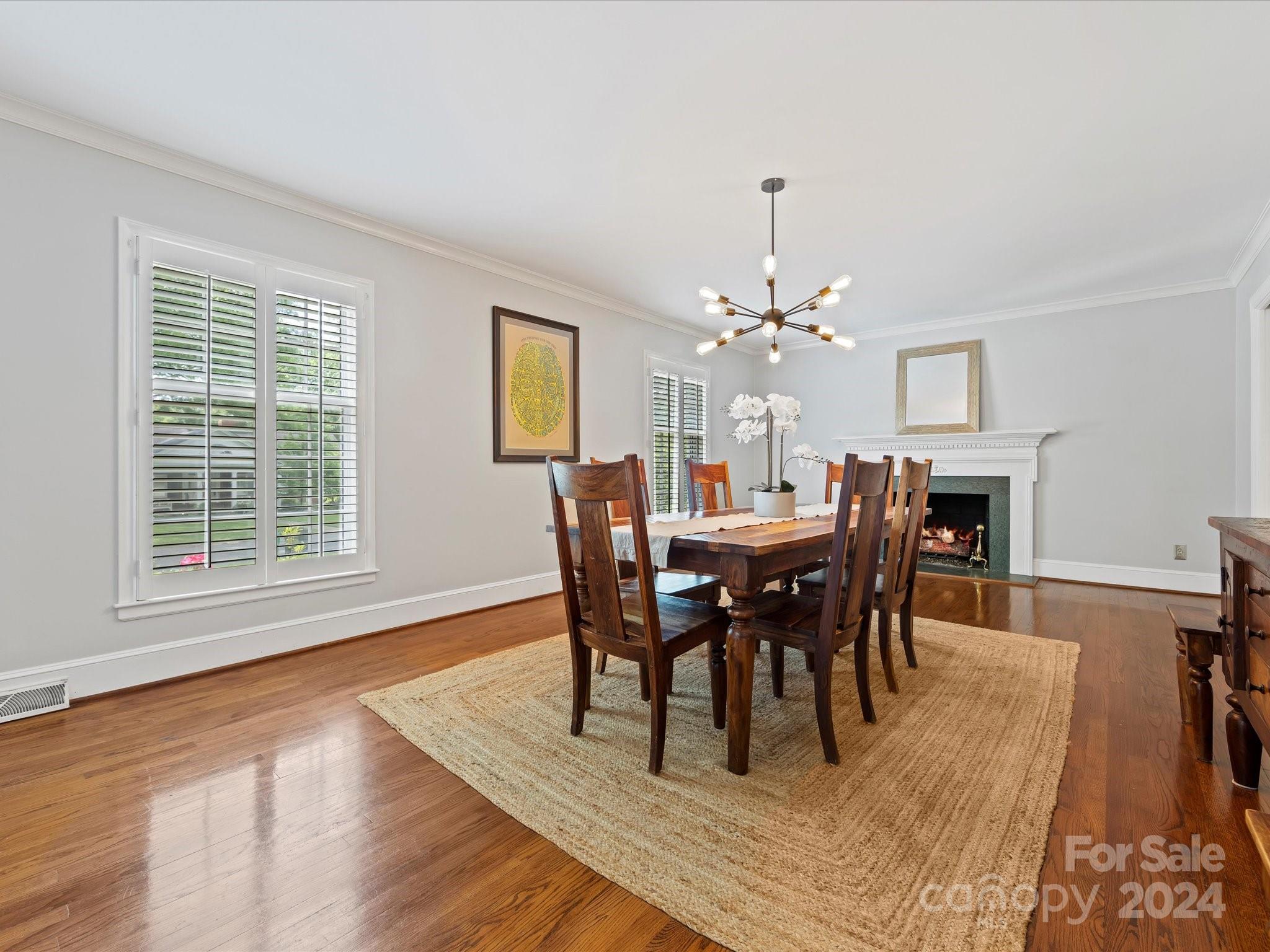 3200 Wickersham Road Charlotte, NC 28211 - Photo 4 of 35 a view of a dining room with furniture a chandelier and wooden floor