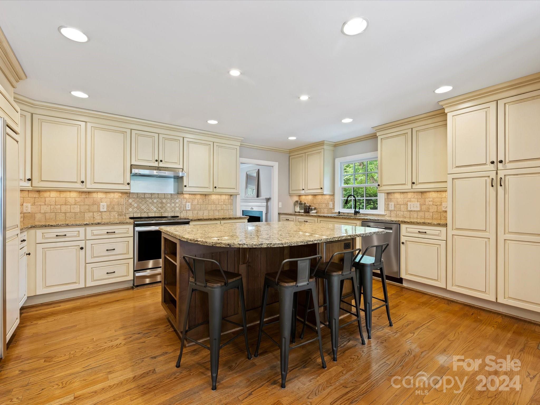 3200 Wickersham Road Charlotte, NC 28211 - Photo 10 of 35 a kitchen with stainless steel appliances granite countertop a table chairs sink refrigerator and cabinets
