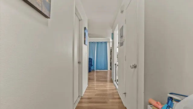 a view of a hallway with wooden floor and staircase