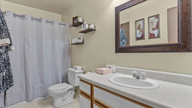 a bathroom with a sink vanity mirror and toilet