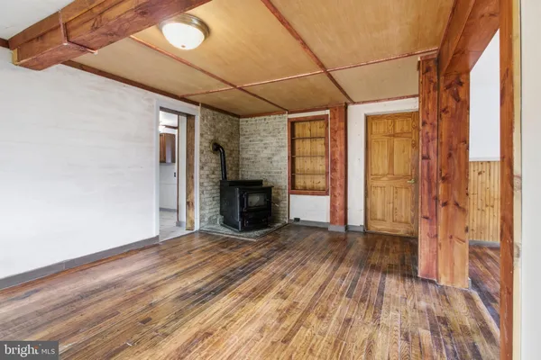 a view of empty room with wooden floor and fireplace