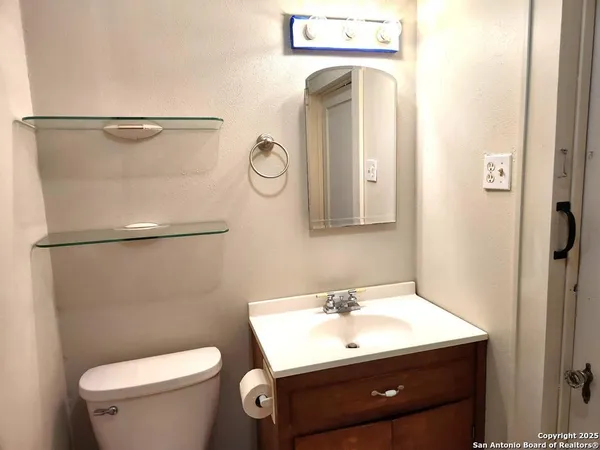 a bathroom with a sink a toilet and a mirror