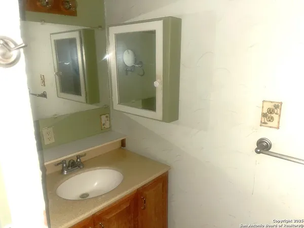 a bathroom with a sink vanity granite tub shower and a mirror