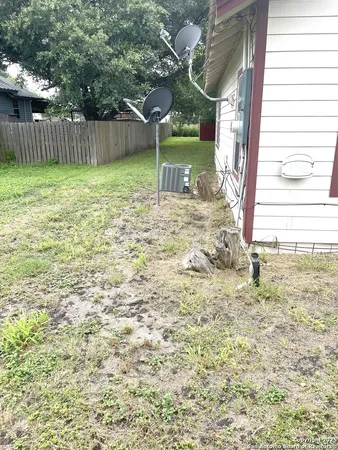a view of a yard in front of a house with a large tree