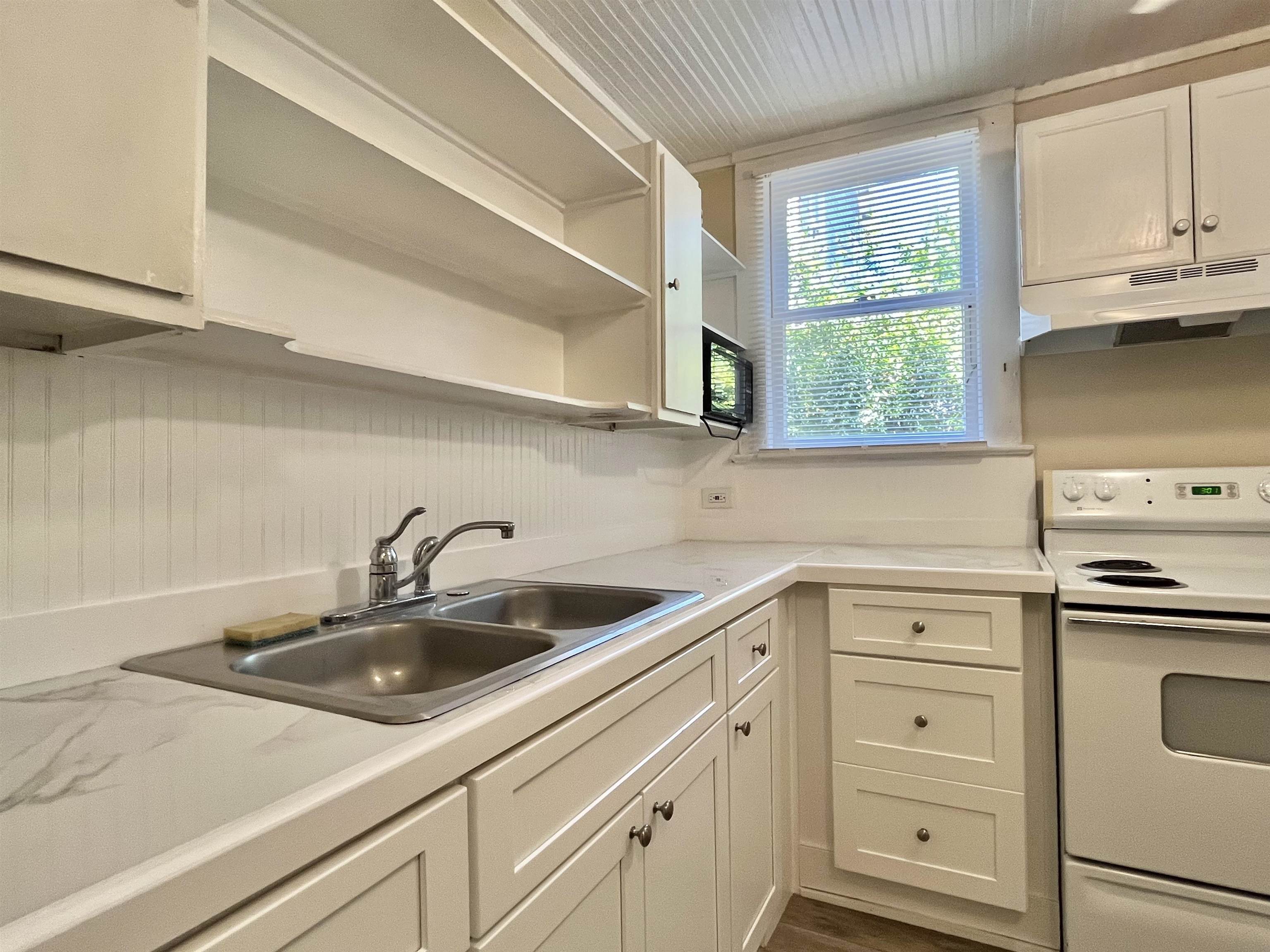 25 Desoto Place, Unit 1 St. Augustine, FL 32084 - Photo 4 of 12 a kitchen with white cabinets and a sink