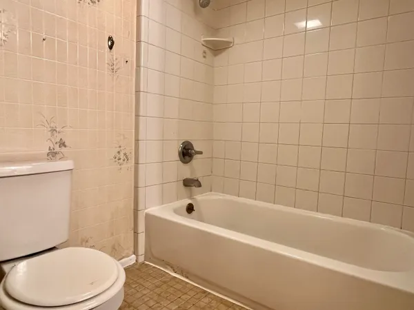 a white bath tub sitting next to a white toilet