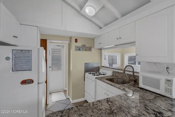 a kitchen with sink refrigerator and stove