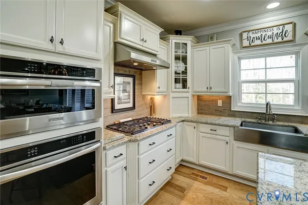 a kitchen with stainless steel appliances granite countertop a stove and a sink