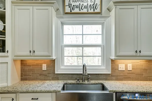 a kitchen with granite countertop sink and window