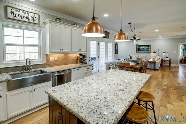 a kitchen with stainless steel appliances granite countertop a sink a stove and a wooden floors