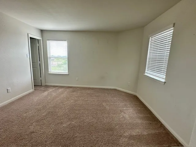 an empty room with windows and closet