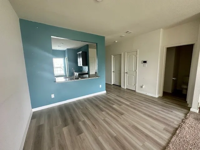 a view of a room with wooden floor and a bathroom