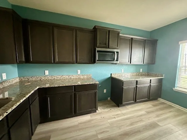 a kitchen with a sink dishwasher a stove top oven a refrigerator with island and cabinets