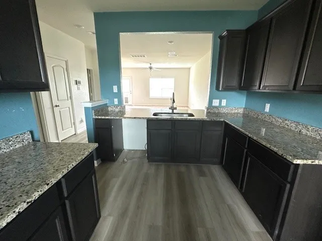 a kitchen with granite countertop sink stove and cabinets