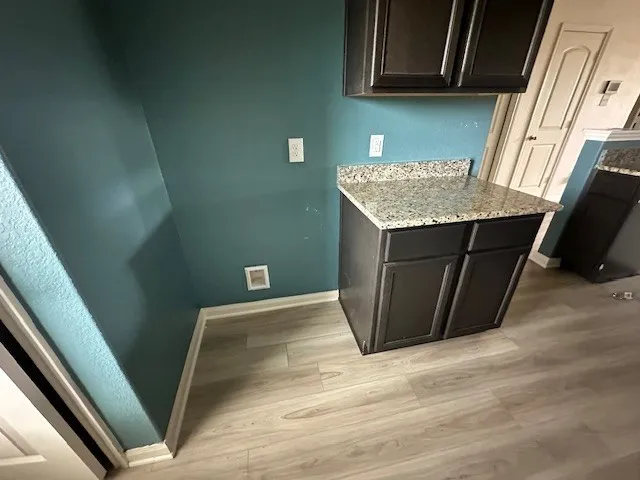 a view of kitchen with wooden floor and cabinets