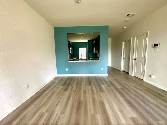 a view of a room that has wooden floor and a window