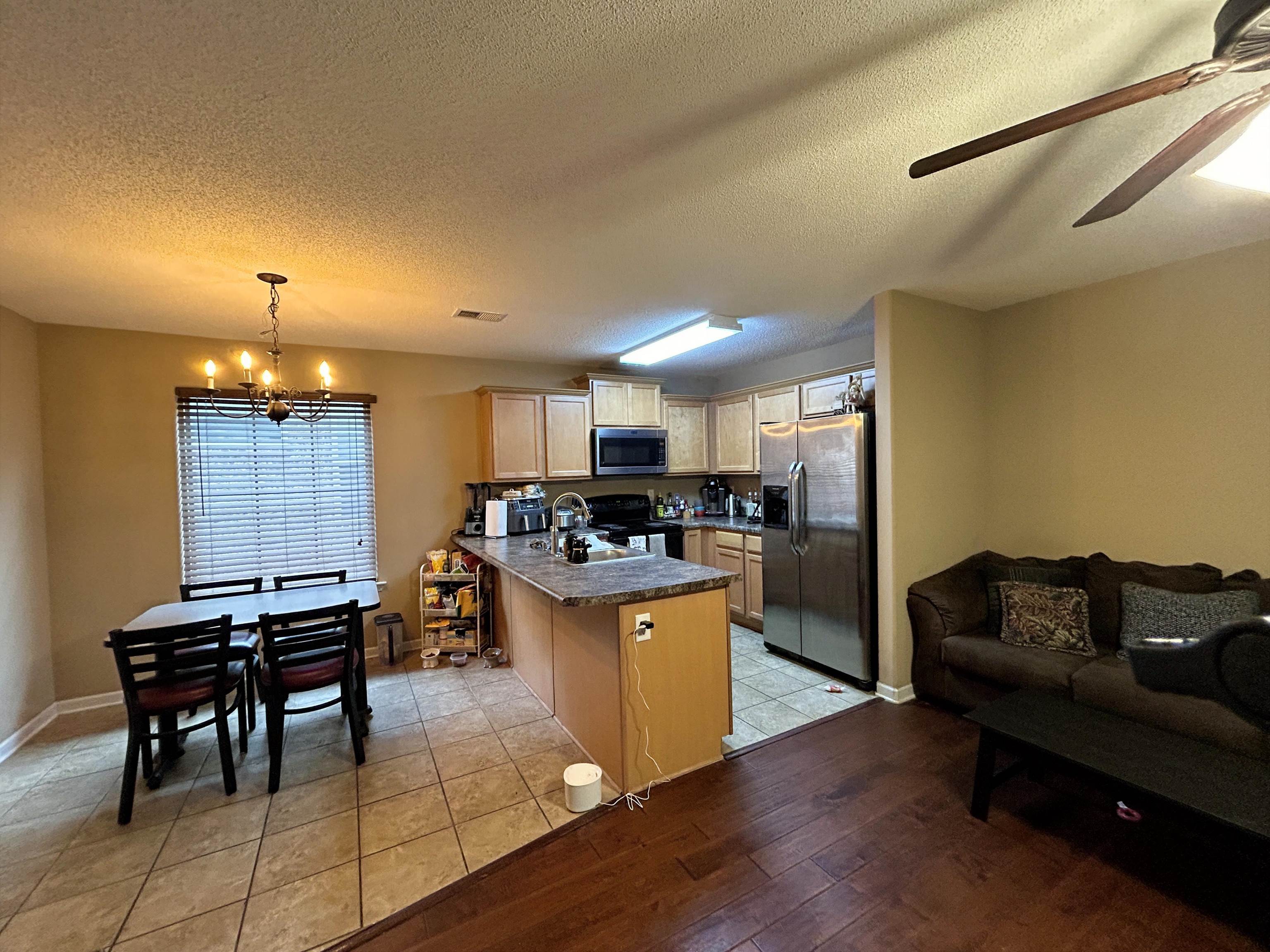 7927 Lowrance Road Memphis, TN 38125 - Photo 4 of 13 Kitchen featuring appliances with stainless steel finishes, a peninsula, ceiling fan, light wood-style floors, and decorative light fixtures
