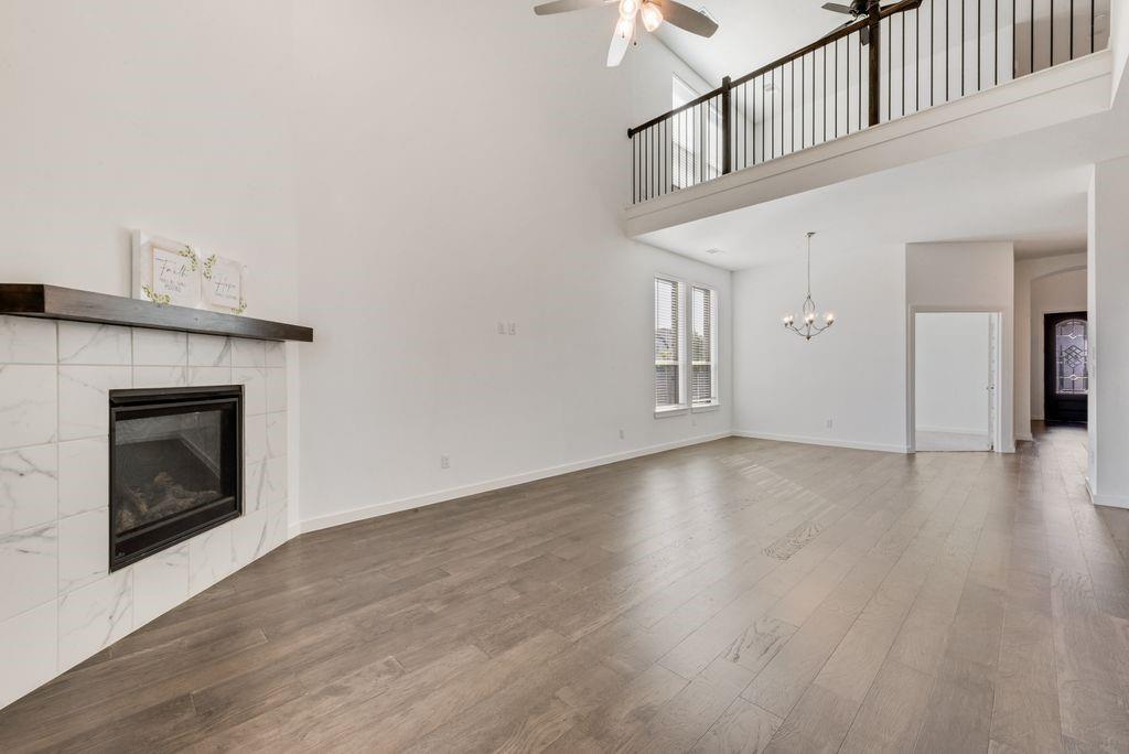 7001 Spring Park Drive Little Elm, TX 76227 - Photo 11 of 38 a view of an empty room with wooden floor and a fireplace