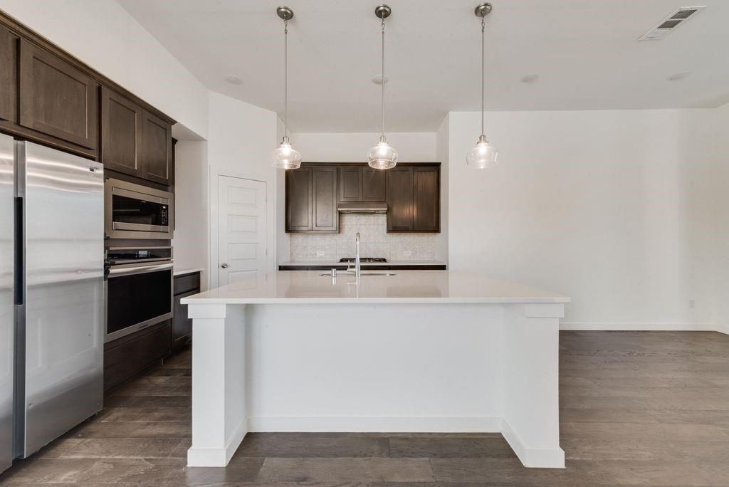 7001 Spring Park Drive Little Elm, TX 76227 - Photo 13 of 38 a kitchen with stainless steel appliances a stove a sink and a refrigerator