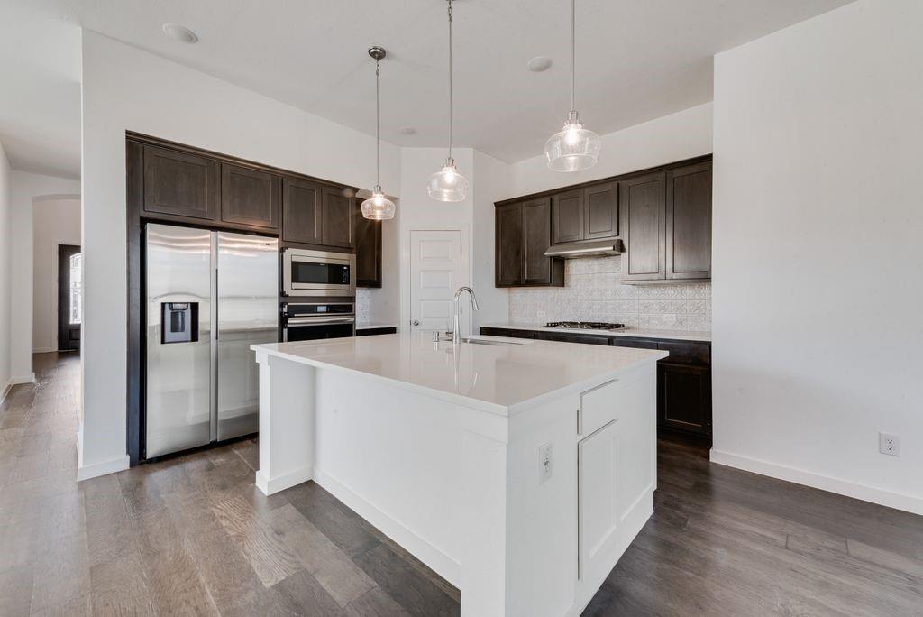 7001 Spring Park Drive Little Elm, TX 76227 - Photo 14 of 38 a kitchen with stainless steel appliances a refrigerator sink and microwave