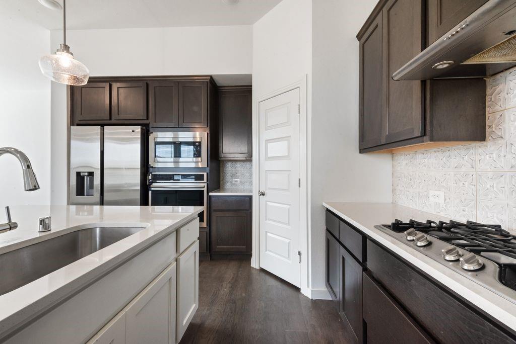 7001 Spring Park Drive Little Elm, TX 76227 - Photo 16 of 38 a kitchen with stainless steel appliances granite countertop a sink stove and refrigerator