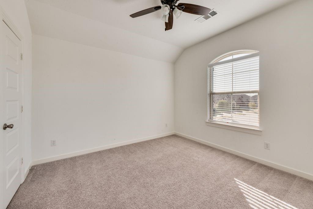 7001 Spring Park Drive Little Elm, TX 76227 - Photo 34 of 38 an empty room with a window and a ceiling fan