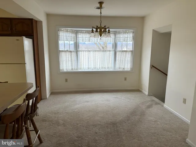 a kitchen with stainless steel appliances a table chairs and a refrigerator