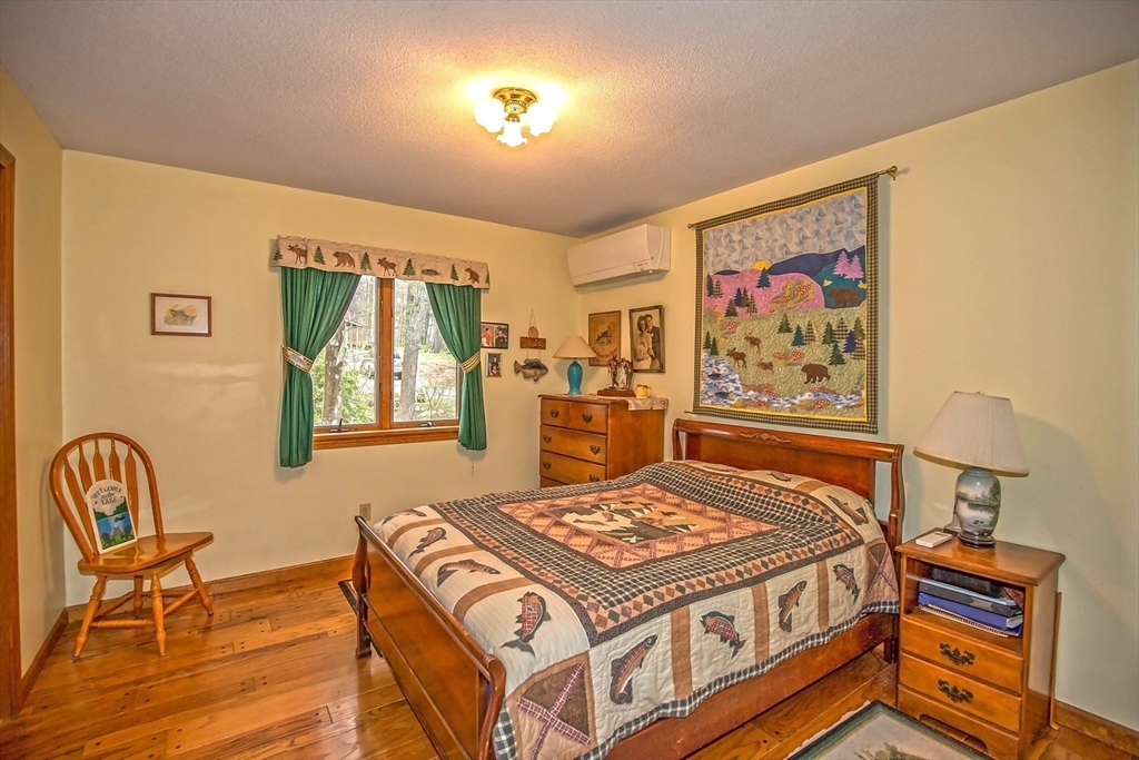32 Woodchuck Hollow Road Tolland, MA 01034 - Photo 25 of 41 a bed sitting in a bedroom next to a window with a lamp on desk and chair