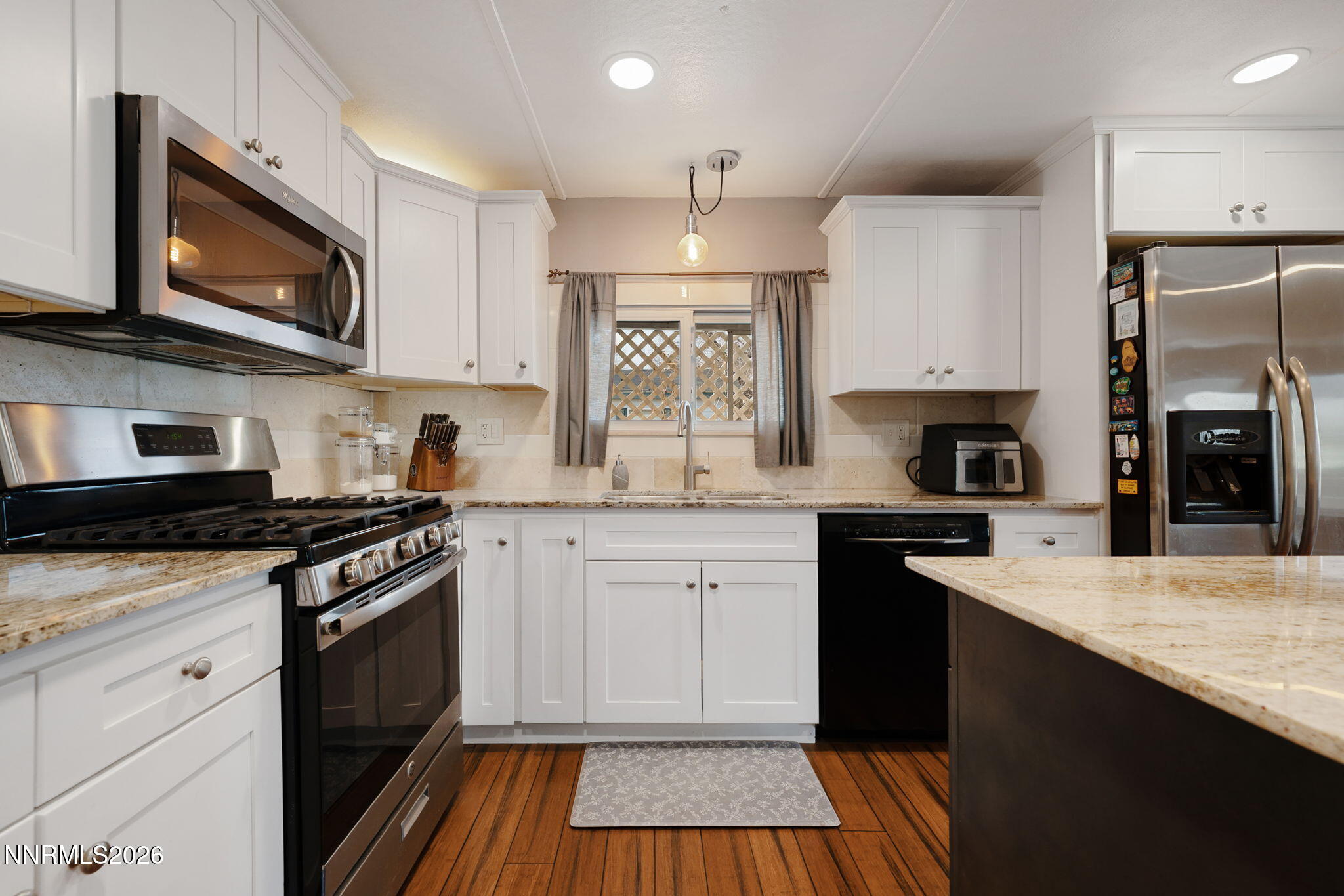 220 Aristocrat Way Reno, NV 89506 - Photo 19 of 35 a kitchen with stainless steel appliances granite countertop a stove top oven a sink dishwasher and a refrigerator with wooden cabinets