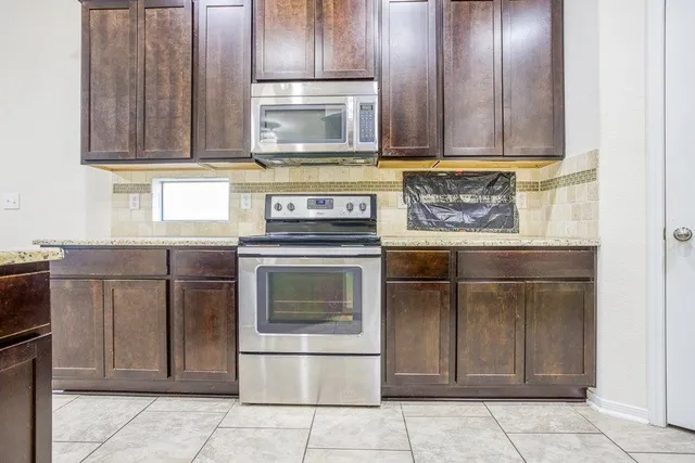 a kitchen with granite countertop a stove and a microwave oven