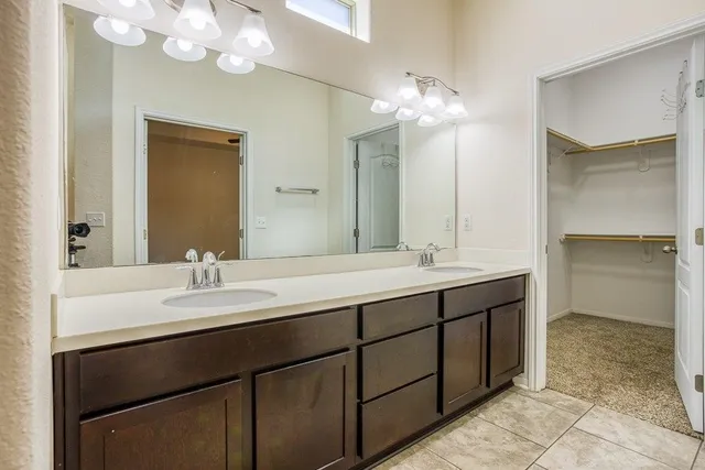 a bathroom with a double vanity sink and a mirror