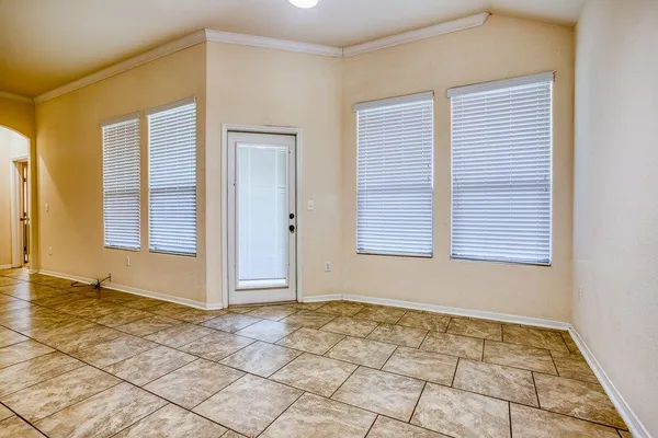 a view of an empty room with window and a bathroom