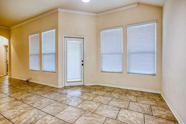 a view of an empty room with window and a bathroom