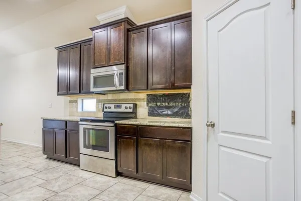 a kitchen with granite countertop stainless steel appliances wooden cabinets and granite counter tops