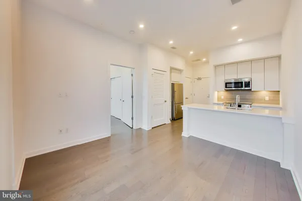 a large kitchen with cabinets and wooden floor