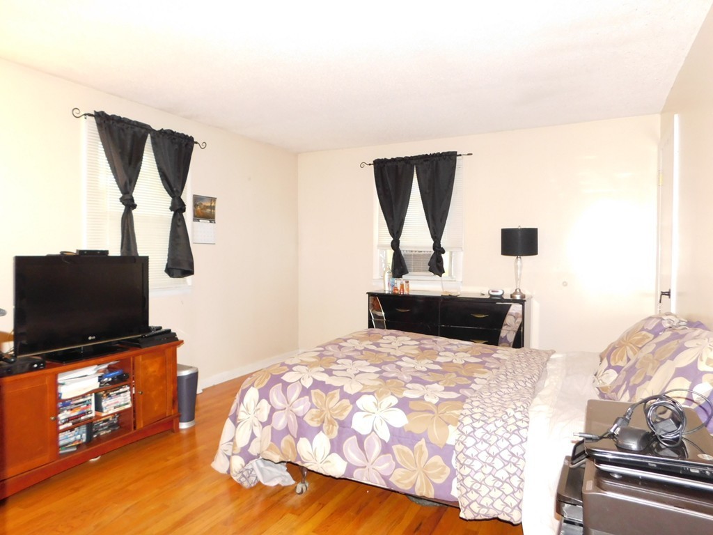 96 Laurence Street Springfield, MA 01104 - Photo 8 of 21 a bedroom with a bed and a flat tv screen on a dresser