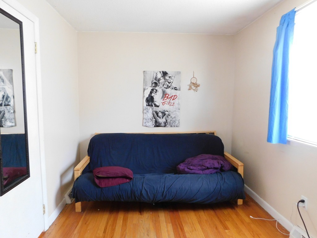 96 Laurence Street Springfield, MA 01104 - Photo 10 of 21 a living room with a bed and a painting on the wall