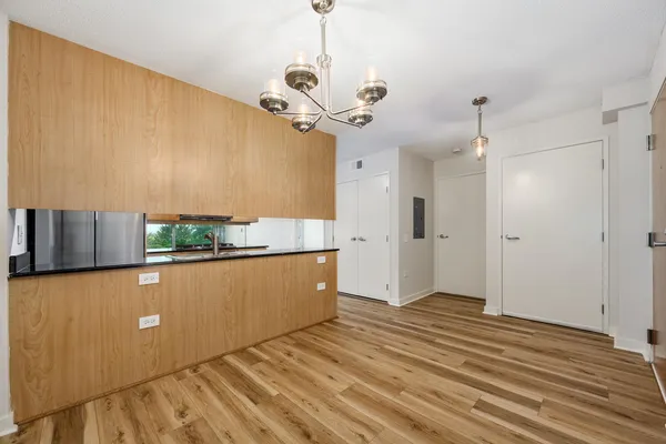 a room with wooden floor and stainless steel appliances