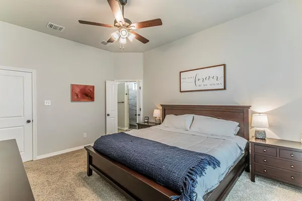 a bedroom with a large bed and a chandelier