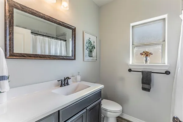 a bathroom with a sink a toilet and a mirror