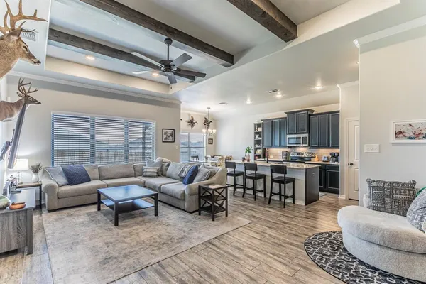 a living room with lots of furniture and view of kitchen