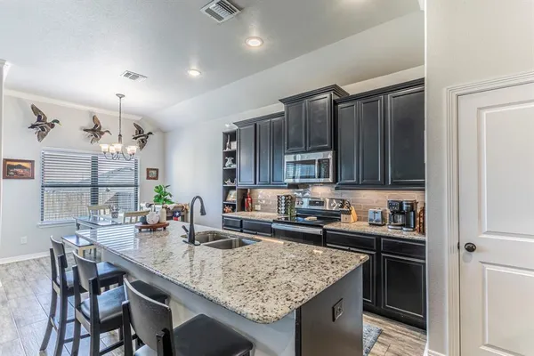 a kitchen with granite countertop a sink and cabinets