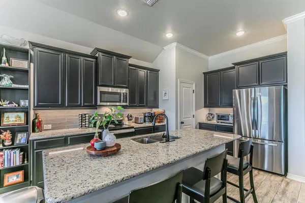 a kitchen with granite countertop a refrigerator and a sink