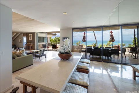 a living room with furniture large windows and wooden floor
