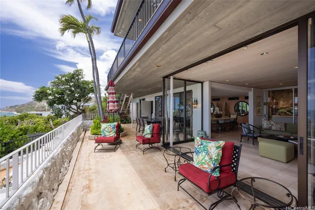 a living room with patio furniture and a potted plant