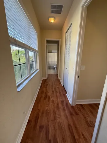 a view of a hallway with wooden floor and staircase