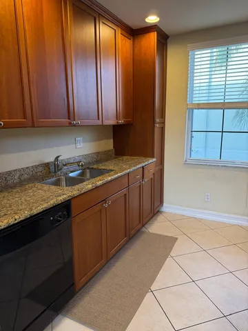 a kitchen with stainless steel appliances granite countertop a sink window and cabinets