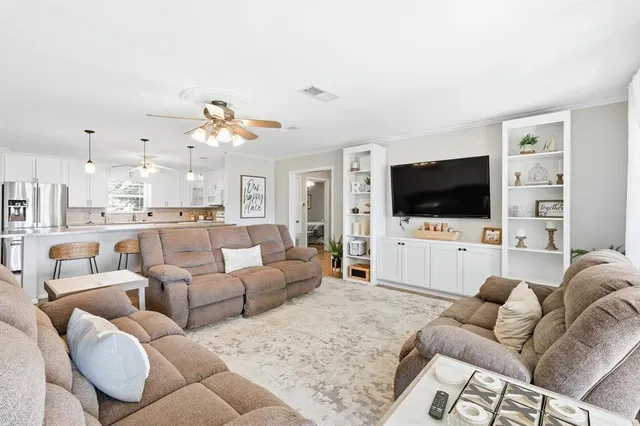 a large white kitchen with lots of counter space and stainless steel appliances