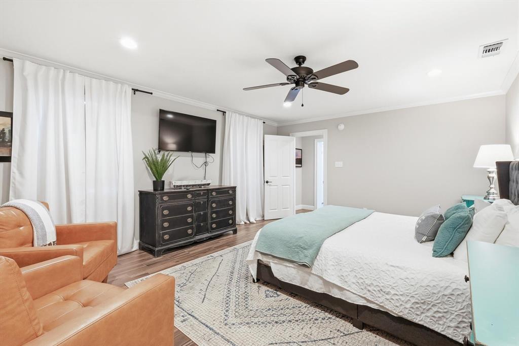 4433 Chapel Road Graham, TX 76450 - Photo 21 of 32 a spacious bedroom with a bed a couch and a flat screen tv